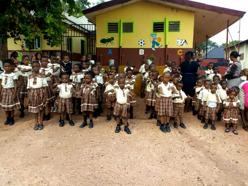 The Sure Edge school compound with pupils gathered in front of the nursery block